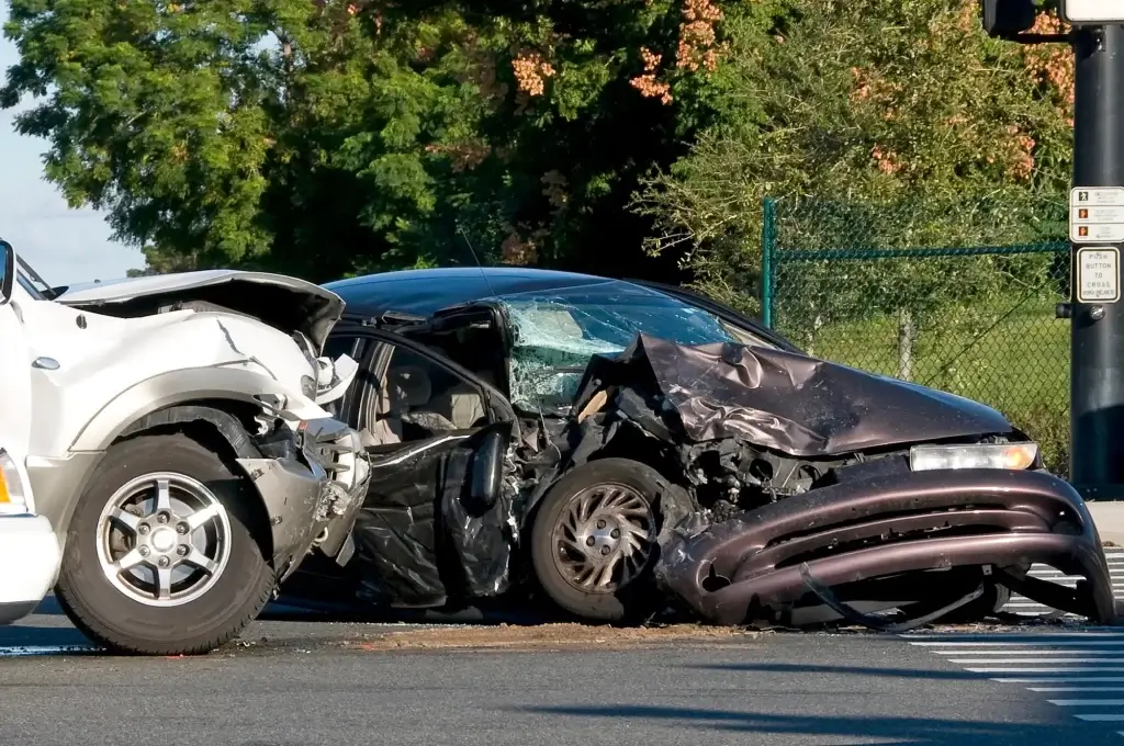 Two cars, a white SUV and a dark sedan, are shown after a collision at an intersection, both vehicles severely damaged at the front—an accident scene that highlights when you might need a Chicago Car Accident Lawyer.