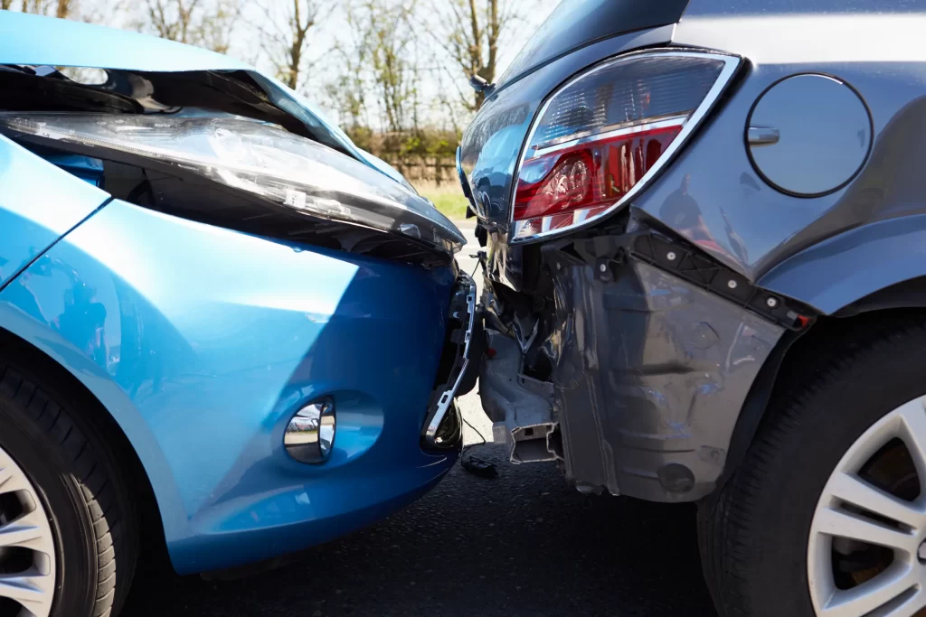 A blue car has collided with the rear of a gray car, resulting in visible damage to both vehicles' bumpers and hoods. A Chicago Car Accident Lawyer can help navigate the aftermath of such collisions.