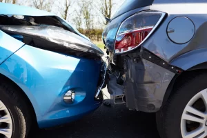 A blue car has collided with the rear of a gray car, resulting in visible damage to both vehicles' bumpers and hoods. A Chicago Car Accident Lawyer can help navigate the aftermath of such collisions.