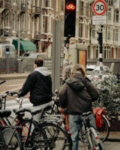 Cyclists waiting at a city intersection in traffic