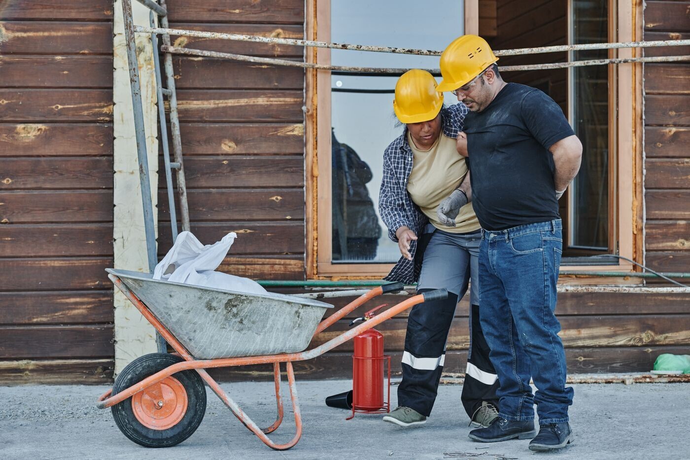 A worker helping an injured co-worker at a construction site
