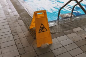 Wet floor caution sign near a pool