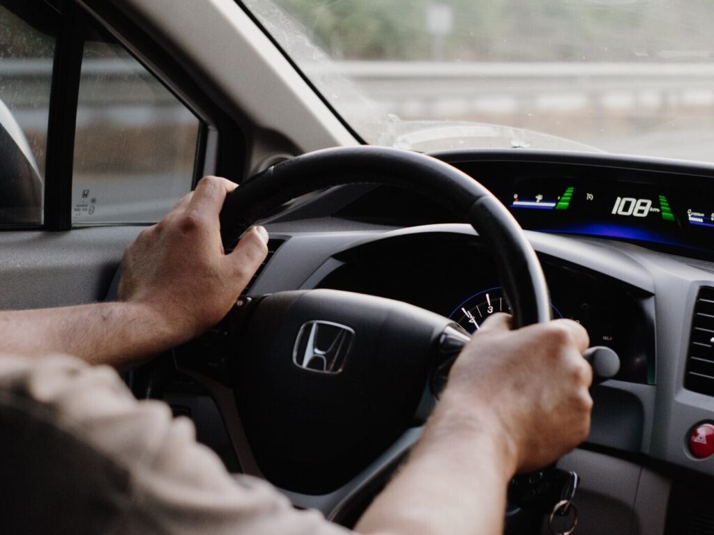 Driver hands on a steering wheel