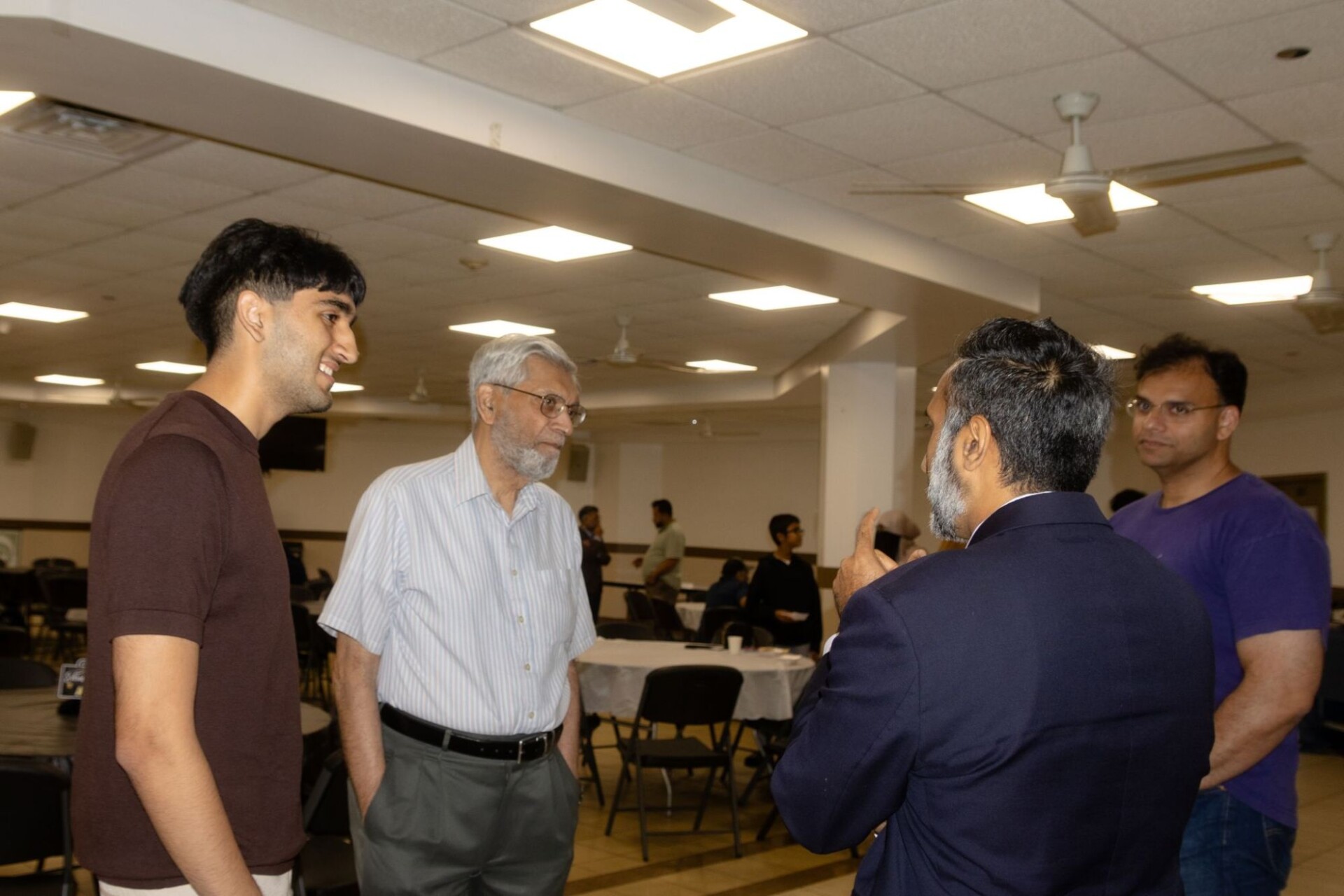 Furqan Mohammed talking with a student and parents after the Pathway to Law panel in Morton Grove